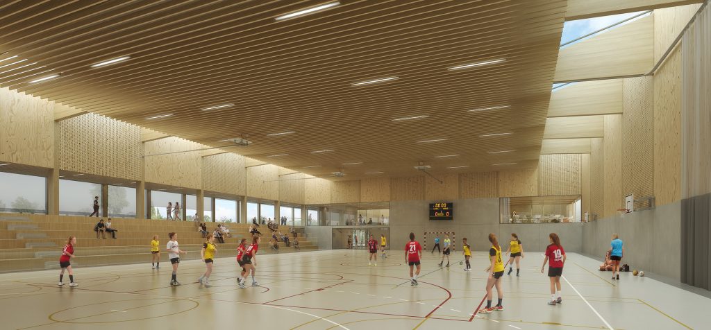 Perspective du concours pour la construction du complexe sportif du futur lycée public de Nort-sur-Erdre, conçu par Barré-Lambot Architectes, montrant l'intérieur chaleureux du gymnase aux surfaces globalement en bois éclairé par une lumière zénithale venant des sheds latéraux et en configuration match de handball féminin.