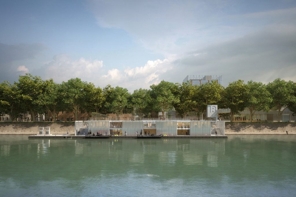 Vue frontale de la base mutualisée des Sapeurs Pompiers de Paris à Saint-Denis, projet lauréat conçu par NTSA, montrant la base fluviale et ses équipements d'intervention sur la Seine devant les platanes du Quai de Saint-Ouen, avec la caserne en résille de métal déployé en arrière-plan.