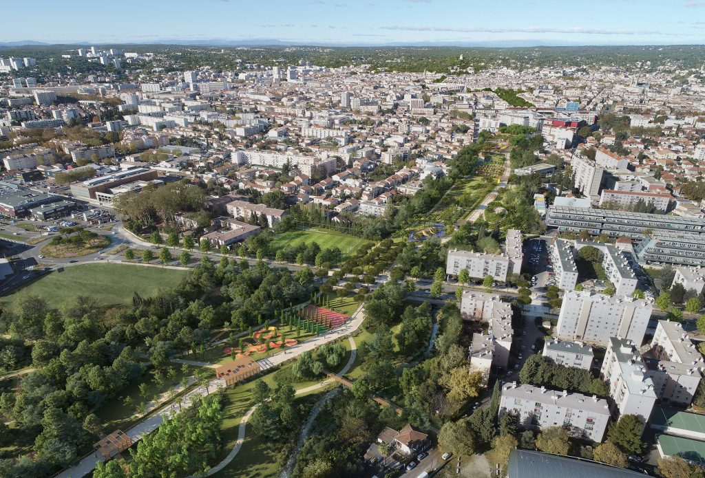 Vue aérienne du Parc Jacques Chirac à Nîmes, projet conçu par Pena Paysages, montrant les 14 hectares de jardins thématiques, les espaces de rencontre et la grande aire de jeux qui jalonnent la Via Nemausa ponctuée d'ombrières le long du Vistre restauré.